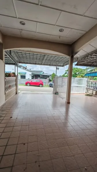 Exterior type: linked terrace house; features: paved flooring, covered porch area, metal roof, front fence, open view of street, surrounded by greenery; style: modern.