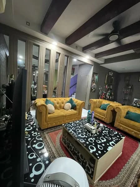 Living features: yellow tufted sofa, 2 yellow tufted armchairs, black and white patterned coffee table, area rug with geometric pattern, wooden ceiling beams, recessed lighting, decorative wall art, wall-mounted shelves, green decorative cushions, wall with textured finish, large flat-screen TV, fan on the floor; style: contemporary.