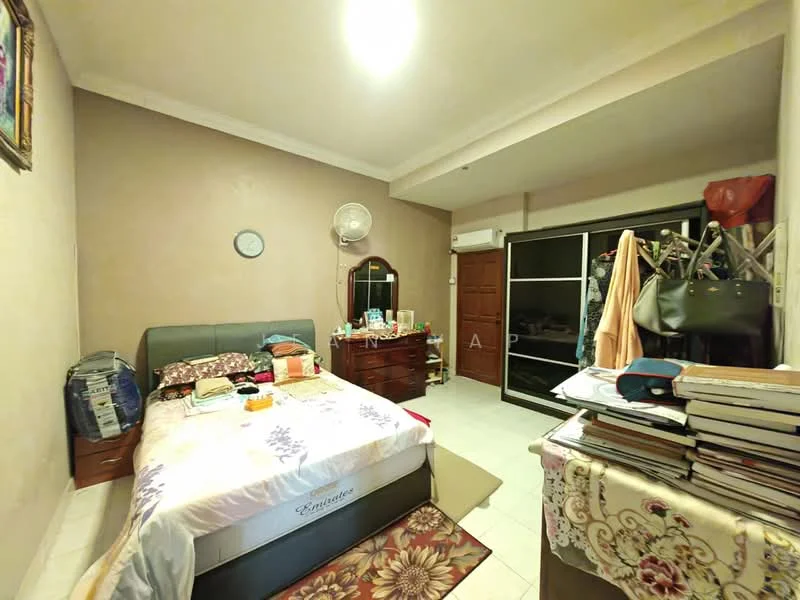 Bedroom features: queen-size bed with floral bedding, wooden bedside table, wall-mounted mirror, built-in wardrobe with sliding doors, ceiling fan, white tiled flooring, painted walls in beige, decorative wall clock, framed artwork on wall, stack of books on bedside table, clothing rack, window with curtains.