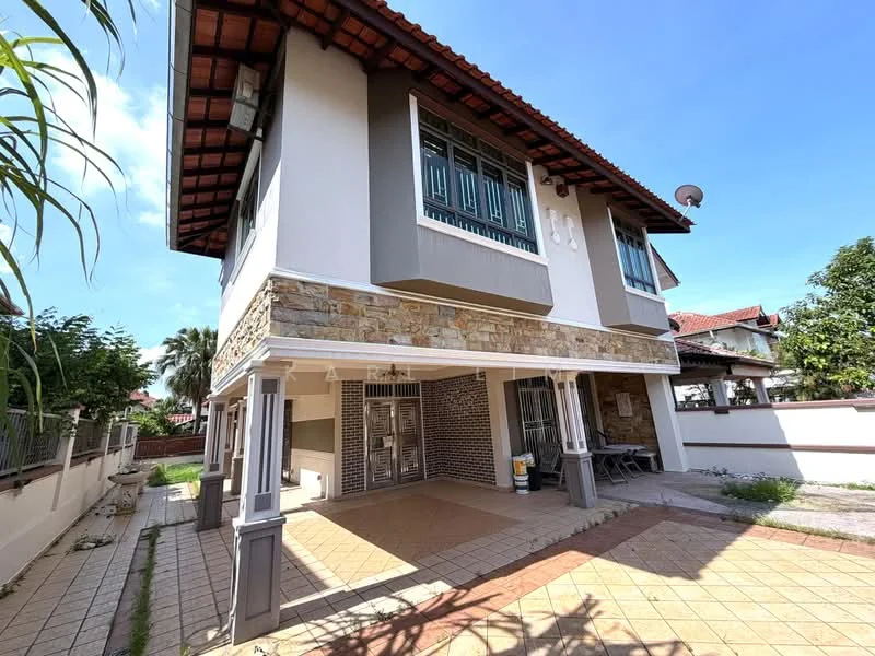 Exterior type: detached bungalow; features: stone cladding on lower facade, white painted facade, red tiled roof, two-storey structure, covered porch area, outdoor seating area, metal grilles on windows, satellite dish on roof, manicured landscaping, paved walkway, surrounded by greenery; style: modern.
