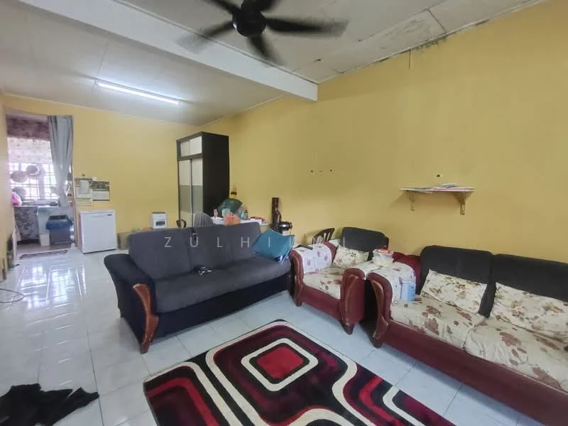 Living features: grey fabric 3-seater sofa, 2-seater wooden sofa with floral upholstery, area rug with geometric pattern in red and black, white tiled flooring, yellow painted walls, ceiling fan, wall-mounted shelf, window with sheer curtains, refrigerator, small table, decorative items on shelf; style: contemporary.
