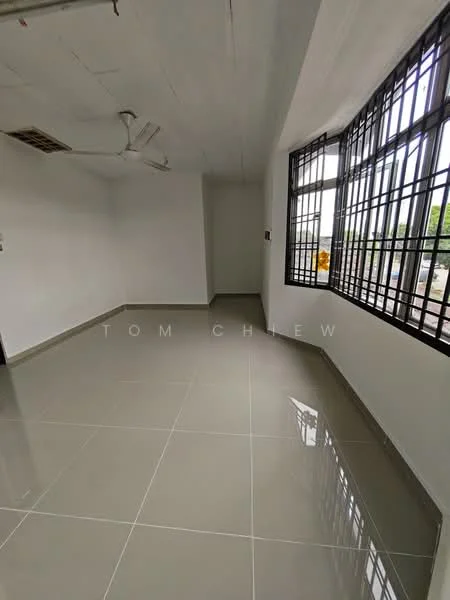 Room features: white painted walls, grey tile flooring, ceiling fan, large windows with black metal grilles, natural light from windows, corner of room visible, no visible furniture, plain ceiling; style: minimalist.