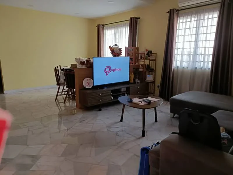 Living features: marble tile flooring, yellow painted walls, floor-to-ceiling windows, sheer curtains, brown leather sectional sofa, wooden coffee table, TV console with TV, decorative shelving unit, dining table with chairs, area rug, air conditioning unit; style: contemporary.