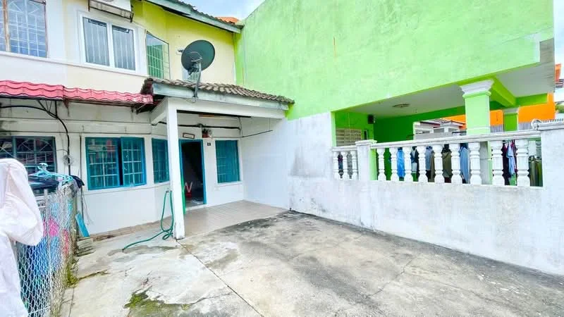 Exterior type: linked terrace house; features: green painted facade, white painted walls, red tiled roof, outdoor patio area, fenced yard, satellite dish, concrete flooring, balustrade with colorful posts; style: modern.