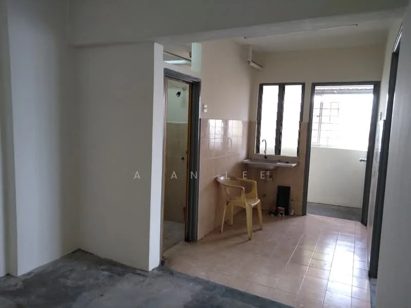 Room features: white painted walls, tile flooring, window with grid pattern, kitchenette area with sink, single plastic chair, doorway leading to another room, open layout, natural light from window.