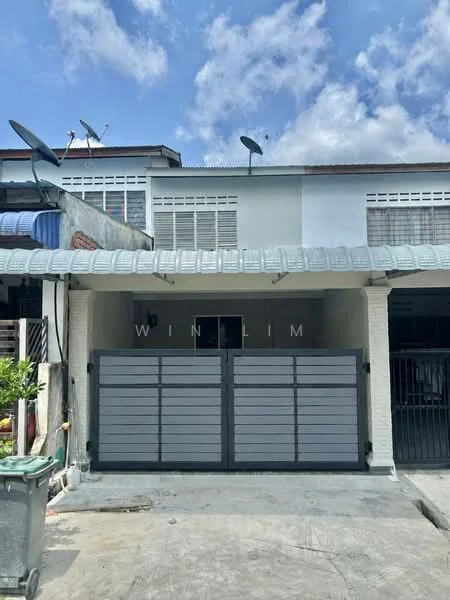 Exterior type: linked terrace house; features: grey painted facade, flat roof, double-storey, metal gate, concrete driveway, satellite dishes on roof, windows with grilles, manicured front garden; style: modern.