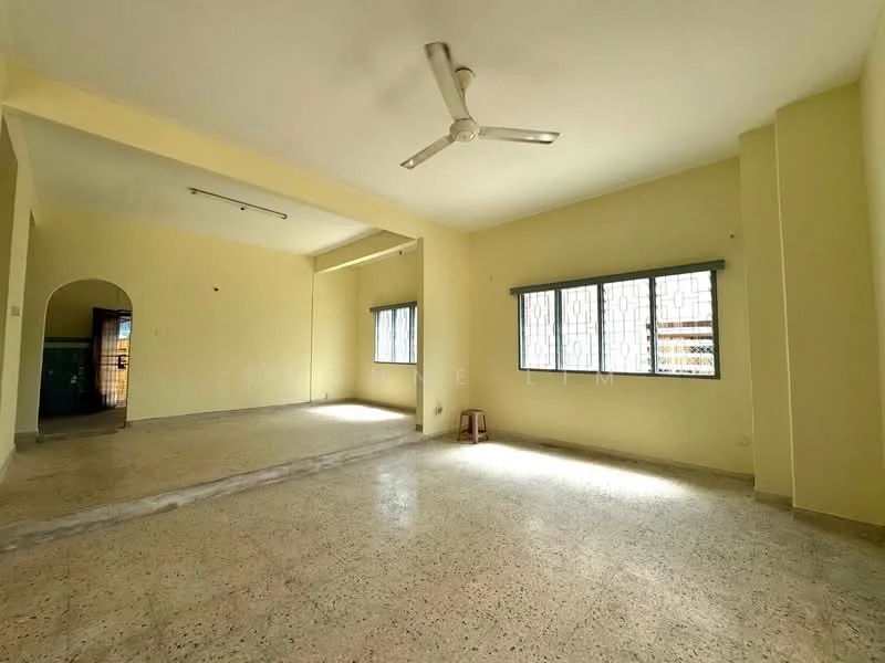 Living features: yellow painted walls, polished concrete flooring, ceiling fan, two windows with metal grills, natural light from windows, open layout, corner space, no visible furniture.