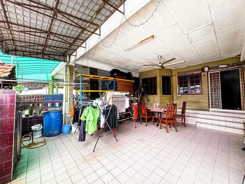 Room features: tiled flooring, ceiling fan, outdoor dining table with chairs, clothes drying rack, laundry area, brick wall, windows with grills, overhead roof structure.