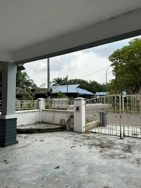 Exterior features: open-air parking lot, fenced perimeter, gate at entrance, concrete flooring, surrounded by greenery, visible road access.