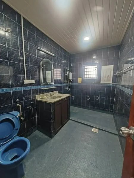 Bathroom features: blue ceramic tile walls, grey ceramic tile flooring, single-sink vanity with wood cabinet, chrome basin mixer faucet, framed mirror, one-piece toilet, handheld shower, shower area with glass partition, wall-mounted showerhead, window for natural light; style: modern.