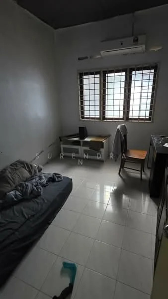 Room features: white painted walls, black ceiling, white tiled flooring, single bed with grey bedding, wooden chair, desk with drawers, air conditioning unit, window with grid pattern, cleaning tool on floor.