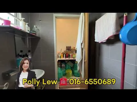 Bathroom features: grey tiled walls, grey tiled flooring, toilet, sink, mirror, wooden door, shelves with bottles, hanging towels, cleaning supplies, plastic storage bins.
