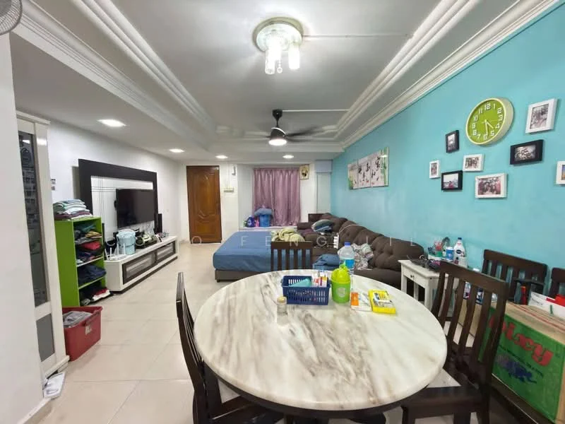 Living features: cream painted walls, blue accent wall, white ceiling with crown moulding, 5-blade ceiling fan with light, recessed downlights, L-shape sectional sofa in brown, coffee table, TV console, wall-mounted TV, area rug, dining table with marble top, wooden dining chairs, decorative wall clock, framed photographs; style: modern.