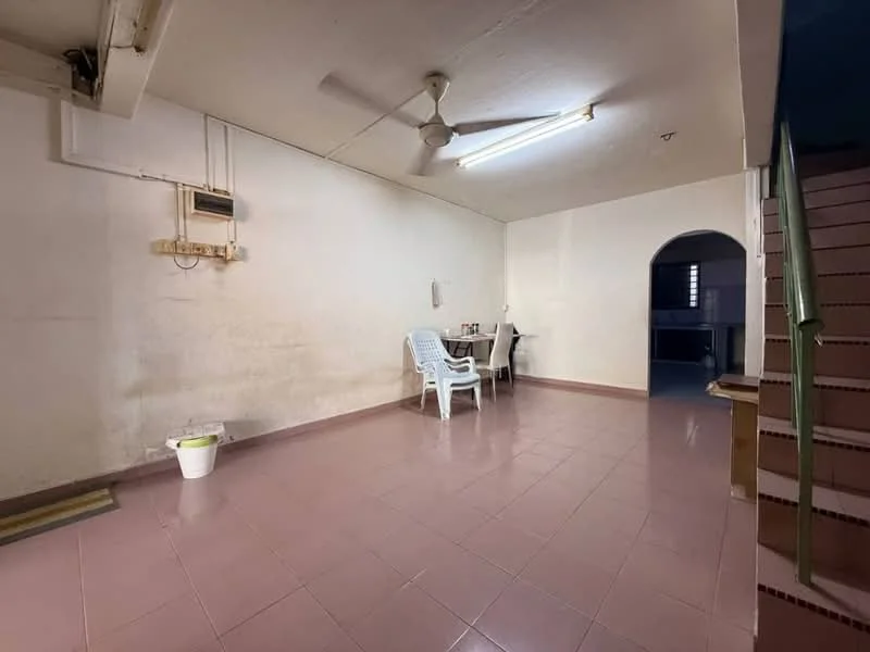 Room features: white painted walls, pink tiled flooring, ceiling fan, fluorescent ceiling lights, dining table with chairs, plastic chairs, staircase leading to upper level, wall-mounted electrical outlet, small waste bin.