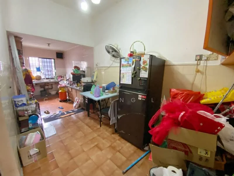 Kitchen features: brown tiled flooring, white painted walls, ceiling fan, wall-mounted split AC, double-door fridge, kitchen table with chairs, sink, various kitchen appliances, cluttered countertop, window with grille, multiple storage boxes, open shelving, cooking area, light fixtures.