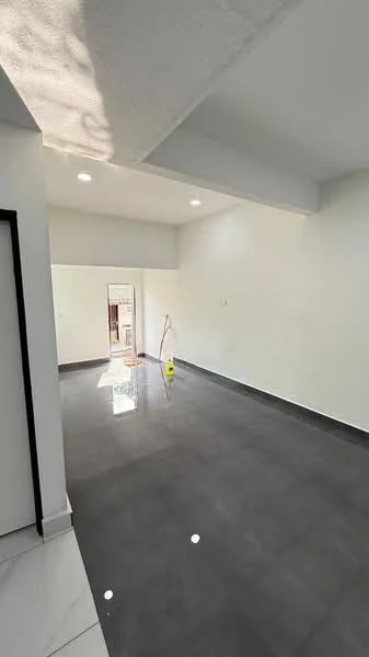 Room features: white painted walls, grey tiled flooring, high ceiling, recessed downlights, doorway leading to another space, clean and uncluttered appearance, natural light from windows, no visible furniture; style: modern.