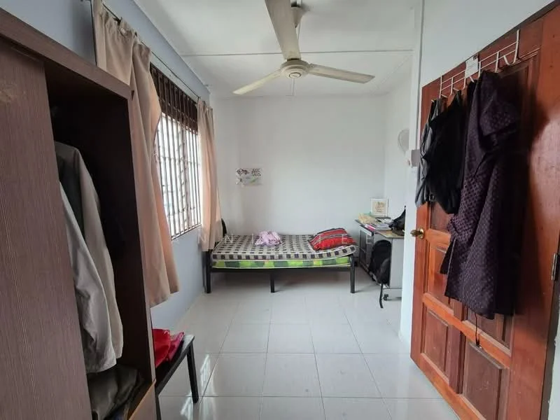 Bedroom features: single bed, ceiling fan, white painted walls, tile flooring, window with wooden grille, curtains, wardrobe, clothes hanging on hooks, decorative wall art.