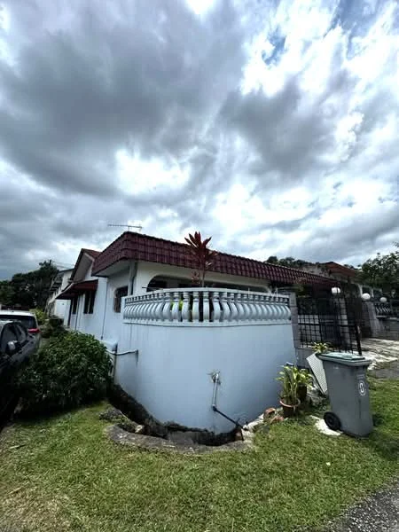 Exterior type: detached bungalow; features: red pitched tile roof, white painted facade, curved wall with decorative railing, manicured lawn, landscaped garden with plants, driveway with interlocking pavers, visible garbage bin, surrounding greenery, fenced perimeter; style: traditional.