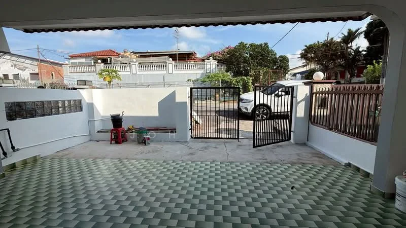 Exterior type: linked terrace house; features: paved driveway, metal gate, fenced perimeter, manicured garden, outdoor seating area, green patterned flooring, surrounded by residential buildings, clear blue sky; style: modern.
