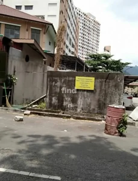 Exterior features: concrete wall, yellow warning sign, paved road, surrounding buildings, overgrown vegetation, metal barrel, construction materials visible.