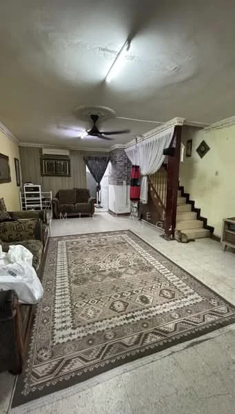 Living features: cream painted walls, tile flooring, 5-blade ceiling fan, sofa set in beige, armchair with patterned upholstery, area rug with geometric pattern, wooden staircase, decorative wall art, curtains, coffee table, side table, open shelving unit; style: traditional.