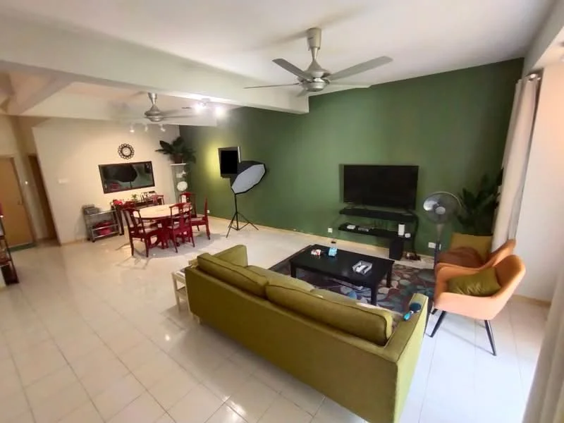 Living features: green accent wall, white painted walls, ceramic tile flooring, 5-blade ceiling fan with light, sofa in olive green, coffee table, wall-mounted TV, TV console, area rug with geometric pattern, freestanding fan, decorative plants, dining table with red chairs; style: modern.