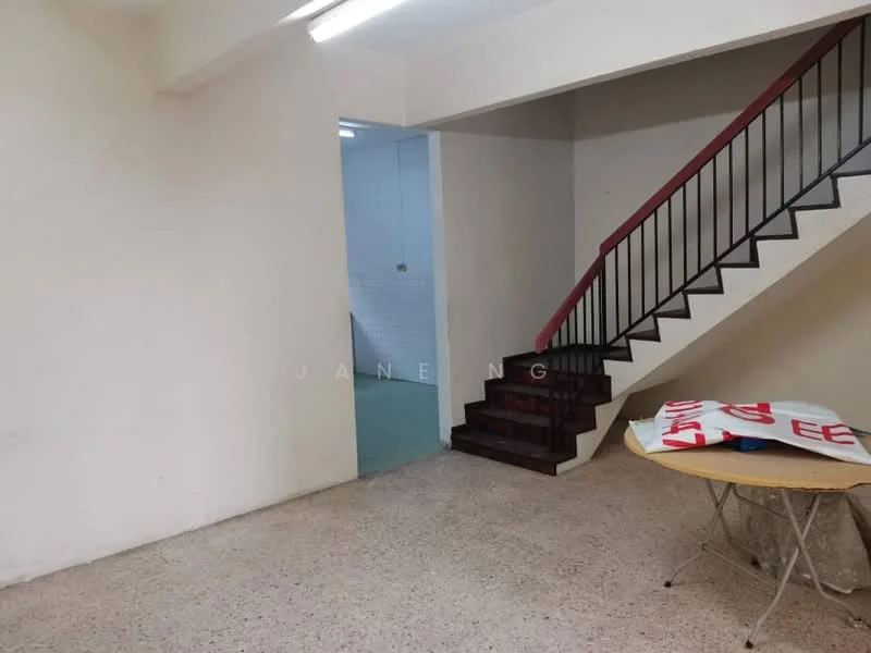 Room features: staircase with metal railing, plain white walls, exposed concrete flooring, ceiling lights, corner table, green tiled wall in background, open space layout; style: minimalist.