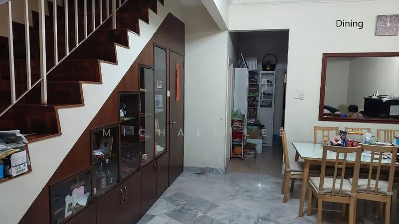 Dining features: marble flooring, wooden dining table with chairs, wall-mounted mirror, built-in display cabinet, staircase with wooden railing, neutral painted walls, decorative wall clock, open layout to adjacent room; style: modern. Room features: white cabinetry, visible pantry or storage area.