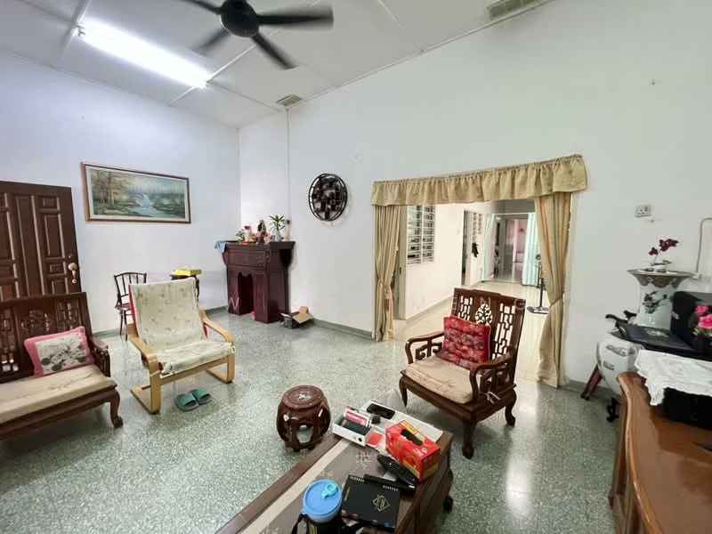 Living features: green speckled tile flooring, white painted walls, ceiling fan, wooden door, wooden furniture, decorative wall clock, framed artwork, curtains, coffee table, two armchairs, wooden cabinet, decorative items on shelves; style: traditional.