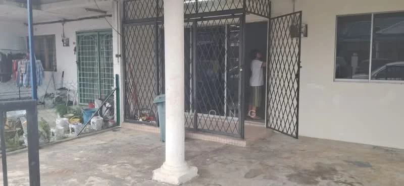 Exterior type: linked terrace house; features: grilled security door, concrete flooring, pillar support, outdoor space, manicured garden area, visible storage items, open entrance, surrounding greenery; style: modern.