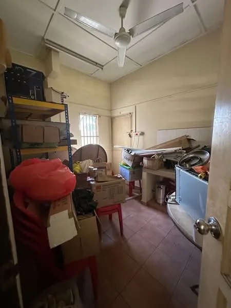 Room features: ceiling fan, tile flooring, light yellow painted walls, shelves with boxes, stacked boxes, red plastic chairs, cluttered space, window with bars.