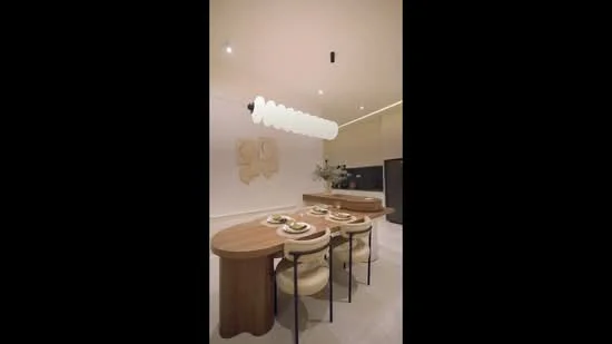Dining features: round wooden dining table, 4 upholstered dining chairs, pendant light fixture, white painted walls, recessed downlights, decorative wall art, neutral color palette, smooth flooring; style: modern.