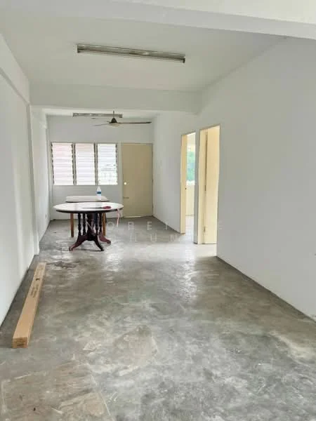 Room features: white painted walls, concrete flooring, ceiling fan, table with four legs, two doorways, windows with horizontal slats, natural light from windows.