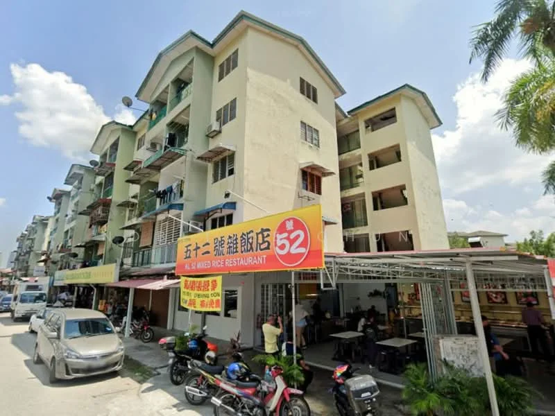 Exterior type: low-rise apartment block; features: yellow painted facade, balconies with metal railings, ground floor commercial space, multiple storeys, visible parking area, surrounded by palm trees, street view, signage for restaurant, windows with grilles; style: modern.