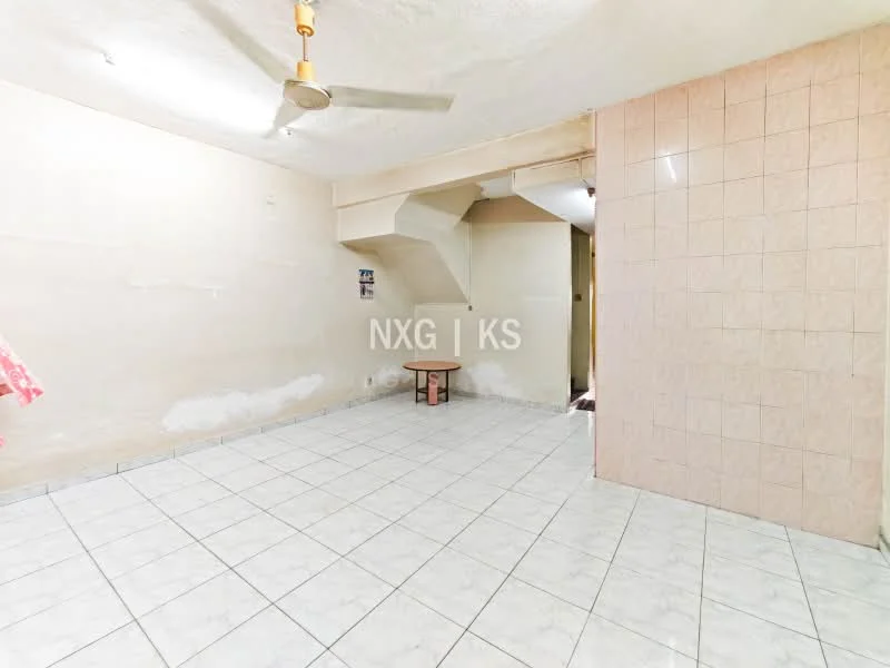 Room features: white painted walls, tile flooring, ceiling fan, small wooden table, staircase visible, light fixtures, corner with tiled wall, no visible windows.
