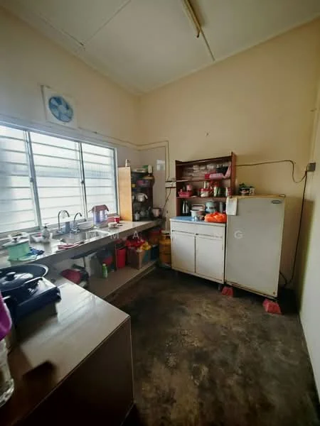 Kitchen features: single-bowl stainless-steel sink, chrome pull-down faucet, wooden cabinetry, countertop with storage underneath, refrigerator, stove with gas burners, various kitchen utensils and containers, window with metal grille, ceiling light fixture, concrete flooring.