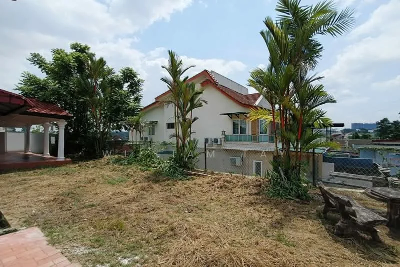 Exterior type: detached bungalow; features: red tiled roof, white painted facade, two-storey structure, surrounded by greenery, manicured lawn, palm trees, fenced perimeter, outdoor patio area, visible air conditioning units; style: traditional.