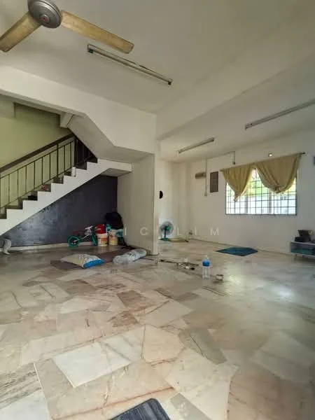 Room features: marble tile flooring, white painted walls, exposed staircase, ceiling fan, window with sheer curtains, air conditioning unit, decorative wall with dark paint, multiple floor mats, cleaning supplies, buckets, plastic bottles.