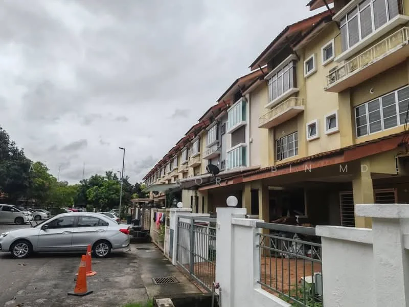 Exterior type: linked terrace house; features: two-storey building, cream painted facade, red tiled roof, balconies on upper floor, windows with white frames, front yard with low wall, paved walkway, parking area visible, surrounded by greenery, urban setting; style: modern.