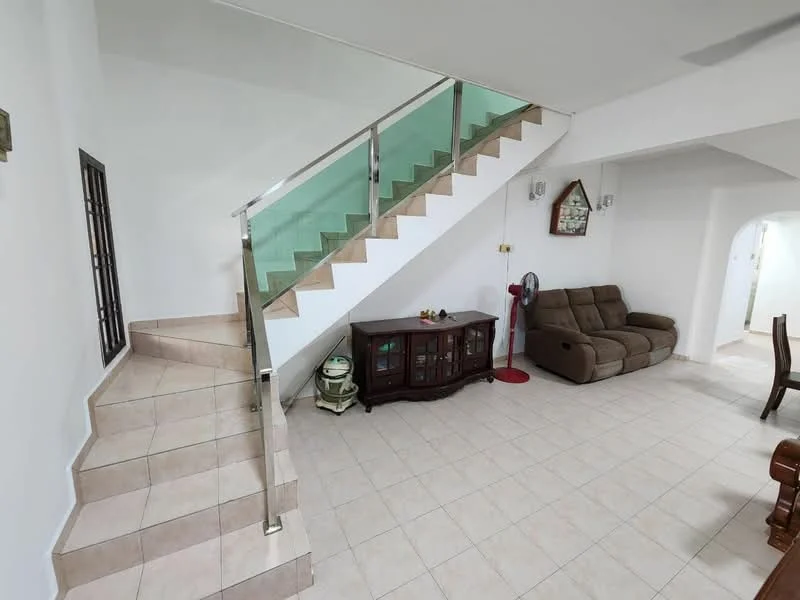 Living features: cream tiled flooring, white painted walls, glass railing on staircase, sofa in brown fabric, wooden coffee table, decorative wall clock, floor fan, sideboard cabinet, recessed lighting; style: modern. Hallway features: cream tiled flooring, white painted walls, staircase with glass railing, arched doorway, recessed lighting; style: modern.