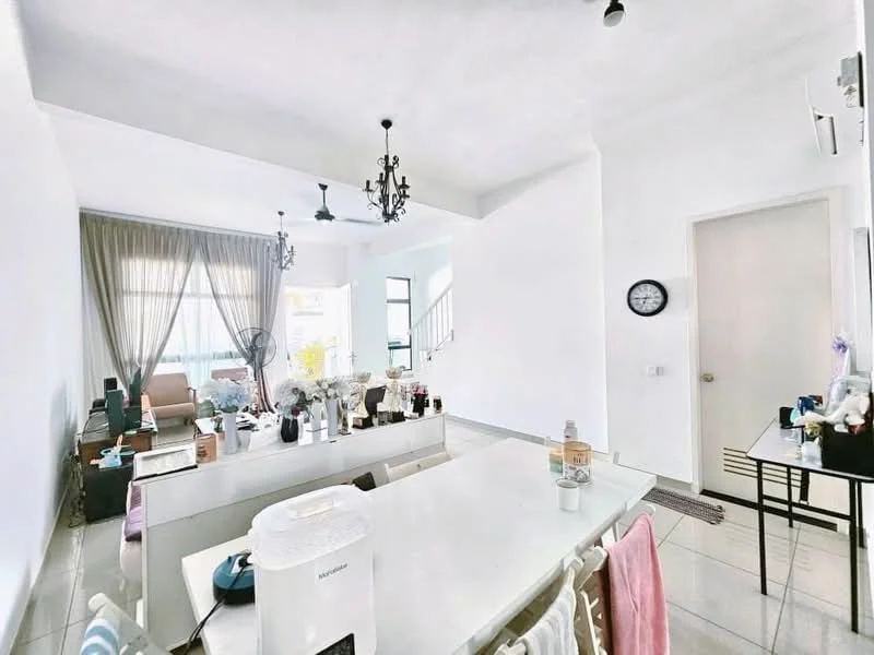 Living features: white painted walls, grey tiled flooring, 5-blade ceiling fan with light, chandelier, large windows with sheer curtains, sofa, coffee table, wall clock, decorative plants, open layout to kitchen, staircase visible in background; style: modern. Kitchen features: white cabinetry, kitchen island, stainless-steel appliances, countertop, open shelving, sink, dish rack, microwave, toaster; style: modern.