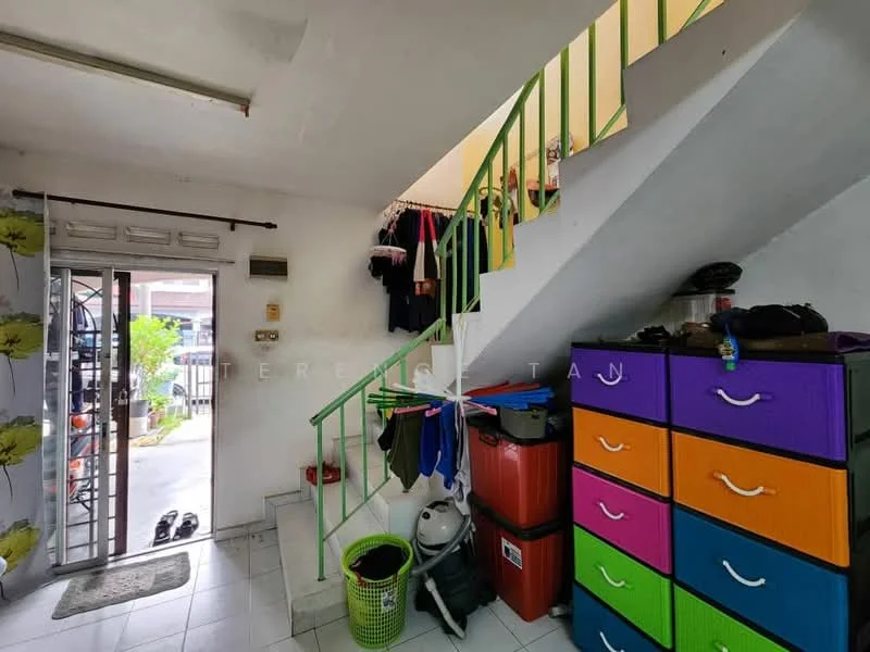 Room features: white painted walls, tiled flooring, green metal staircase, colorful storage drawers in purple, orange, and blue, plastic laundry basket, door leading outside, clothes hanging on railing, shoe rack near entrance; style: modern.