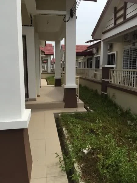 Exterior type: linked terrace house; features: white painted facade, brown accent columns, tiled walkway, manicured lawn, surrounding greenery, gabled roof, visible air conditioning units, porch area; style: modern.