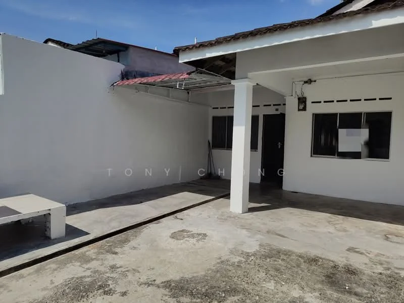 Exterior features: concrete flooring, white painted walls, roof overhang, windows with black frames, open outdoor space, partially shaded area.