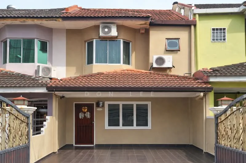 Exterior type: linked terrace house; features: cream painted facade, red tiled roof, 2 wall-mounted split AC units, single wooden door with decorative glass panel, large front window, grey tiled flooring at entrance, decorative wrought iron gate, green accent wall on right side, white window frames, overhanging eaves; style: modern.