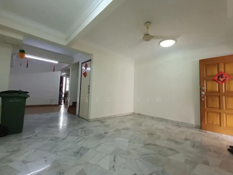 Room features: marble flooring, white painted walls, ceiling fan, round ceiling light, wooden door, green trash bin, decorative wall hanging, doorway leading to another room.