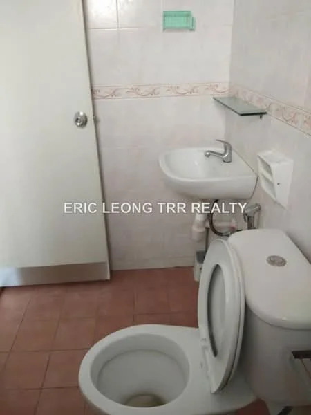 Bathroom features: white ceramic toilet, single-sink vanity with chrome faucet, mirror above sink, white tiled walls, pink tiled flooring, glass shelf above sink, toilet paper holder, door with silver handle.