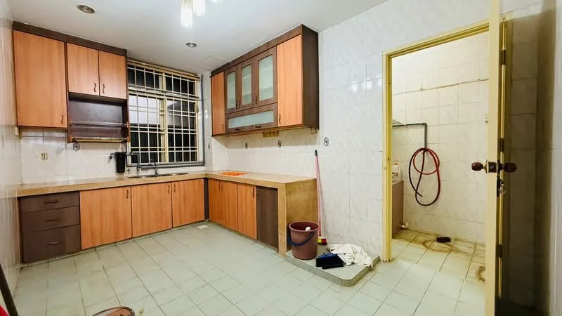 Kitchen features: wood cabinetry in light brown, dark brown lower cabinets, white tiled backsplash, single-bowl stainless-steel sink, chrome pull-down faucet, built-in oven, ceramic tile flooring in light green, window with metal grille, exposed plumbing, cleaning supplies visible, sweeping broom, bucket, white cloth on the floor; style: modern.