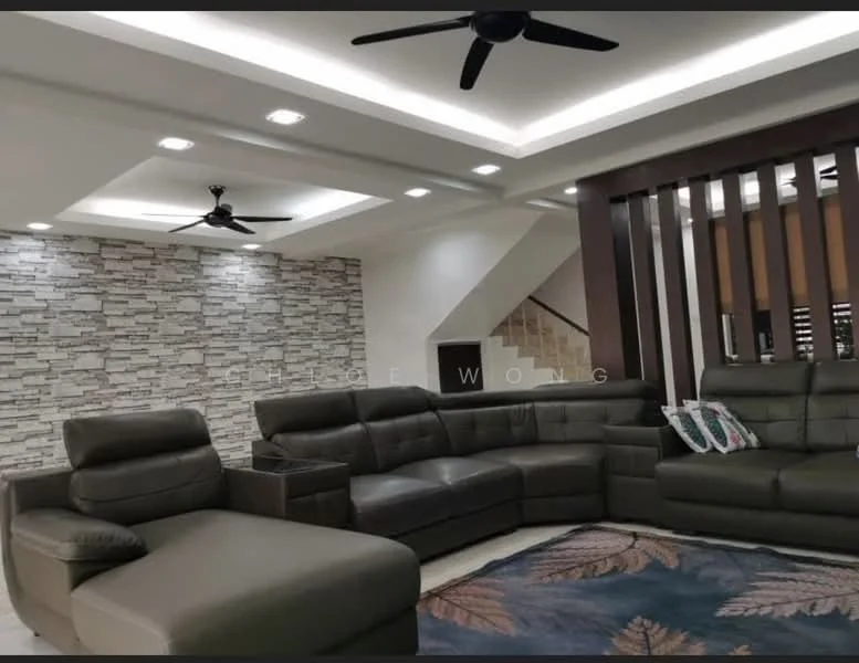 Living features: L-shape sectional sofa in dark grey leather, coffee table, 5-blade ceiling fan with light, recessed downlights, feature wall with stone cladding, decorative wall paneling, area rug with leaf pattern, staircase in background; style: modern.