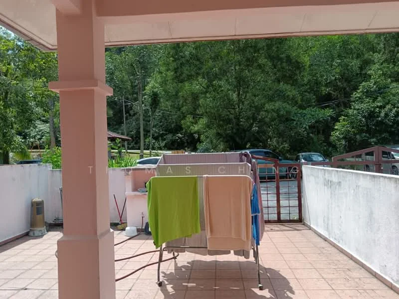 Room features: terracotta tile flooring, white painted walls, clothes drying rack, green towel, white towel, outdoor view of trees, fenced area, vehicles visible in background; view: garden.